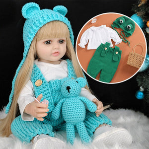 lifelike real-feel baby doll with blonde hair wearing blue knit outfit holding matching teddy bear with extra green outfit and accessories