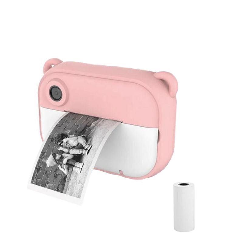 Pink kids instant print camera with bear ears and black-and-white photo print coming out, accompanied by a thermal paper roll refill
