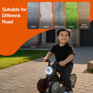 Toddler riding Tiny Biker Anti-Tip Light & Sound Motorcycle on cobblestone with illuminated front light, suitable for various road surfaces